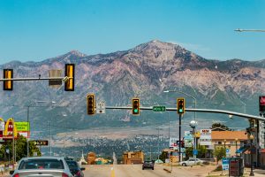 Traffic signs on Utah roads near a mountain.