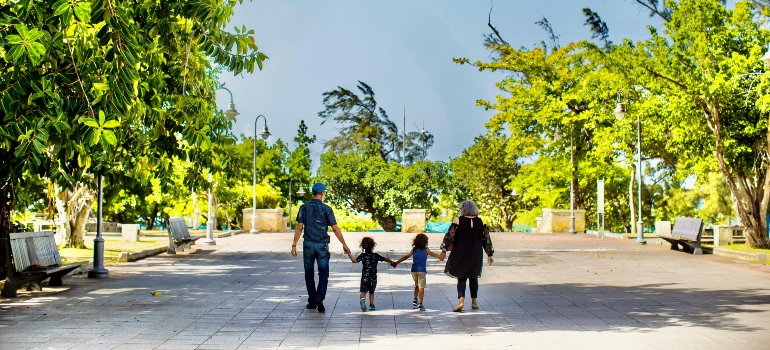 A back shoto of a family holding hands.
