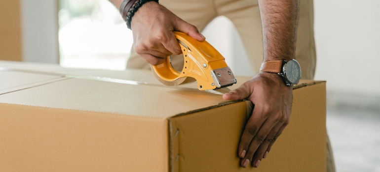 Movers carefully securing a package with protective wrapping to ensure safe transport during a move.