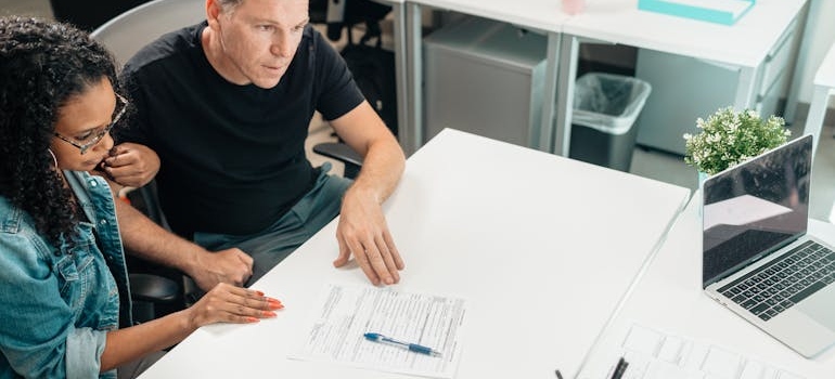 Couple meeting a broker at desk, discussing moving plans