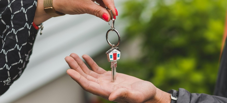 A woman giving someone a house key.
