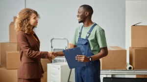 A man and a woman shake hands after finalizing a moving contract.
